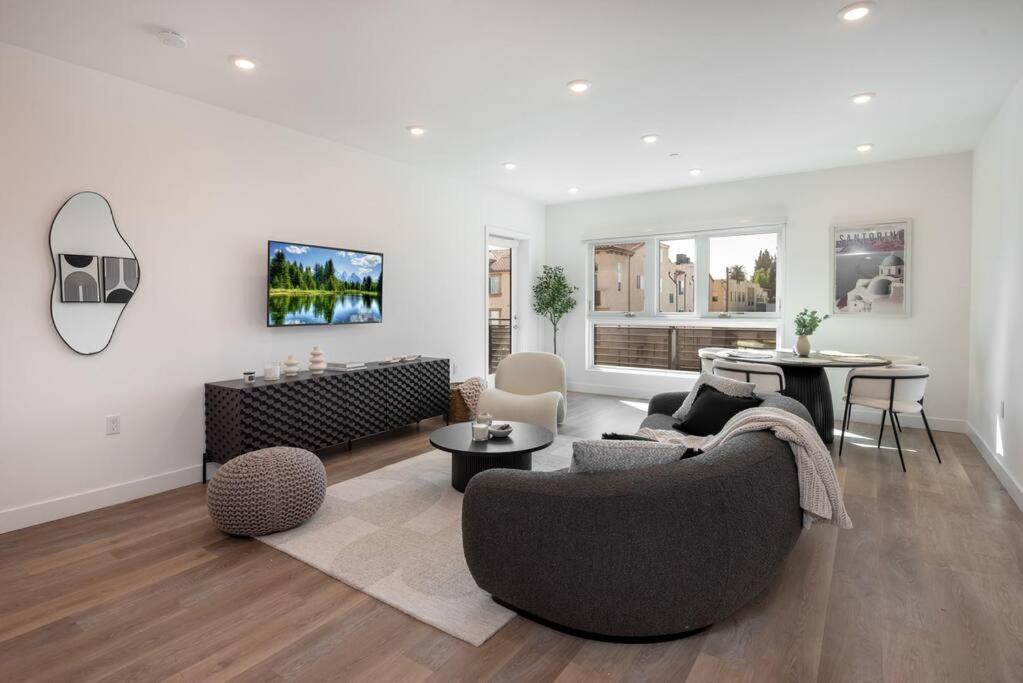 uma sala de estar com um sofá e uma mesa em Deluxe Modern 2-bedroom Condo w/ Roof Deck! em Los Angeles