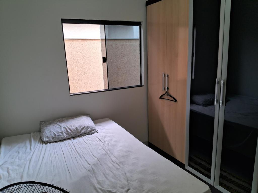 a small bedroom with a bed and a window at Recanto Nascente do Segredo in Campo Grande