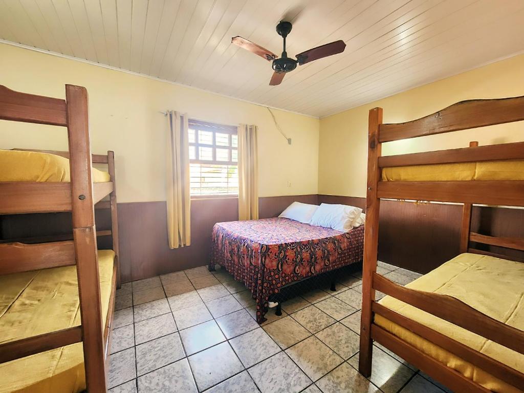 a bedroom with two bunk beds and a ceiling fan at Hostel Casa Gaia - Centro de Arraial d'Ajuda in Porto Seguro
