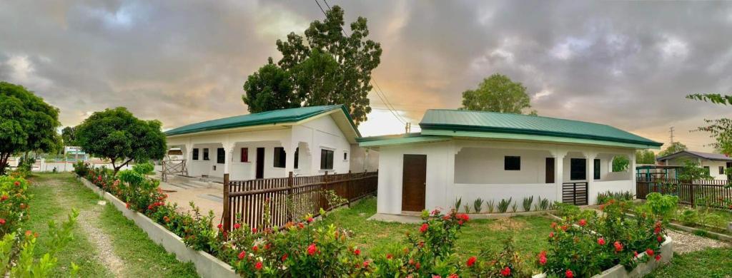 Casa blanca con techo verde y jardín en MAXBELLE MOUNTAIN RESORT, en Daanbantayan