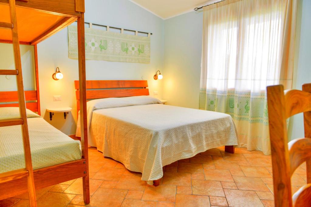 een slaapkamer met twee stapelbedden en een raam bij Nuraghe Bianco in Santa Maria la Palma
