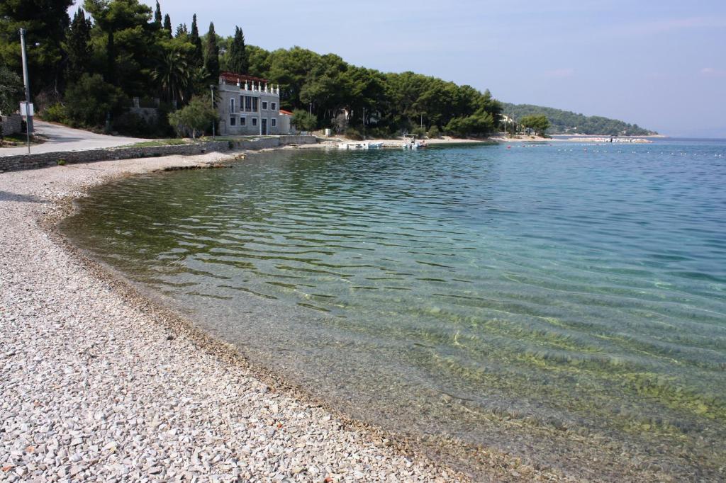 ein großer Wasserkörper mit einem Gebäude am Ufer in der Unterkunft Holiday house with a parking space Cove Piskera, Solta - 21775 in Grohote
