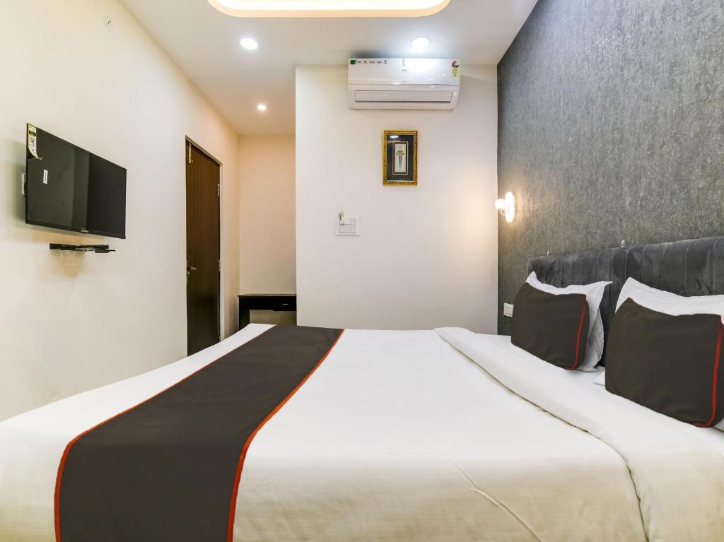 Habitación de hotel con cama y TV de pantalla plana. en Hotel Iconic Stay en Indore