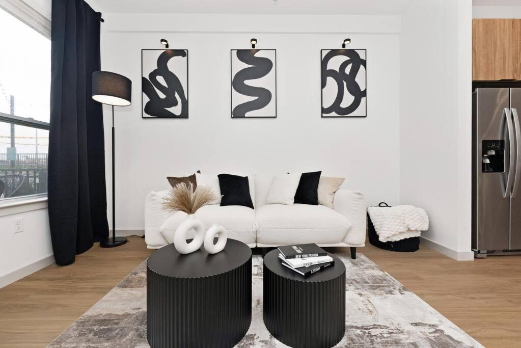 ein Wohnzimmer mit einem weißen Sofa und 2 Tischen in der Unterkunft Modern Luxury Sanctuary Apt in DownTown Boston in Chelsea