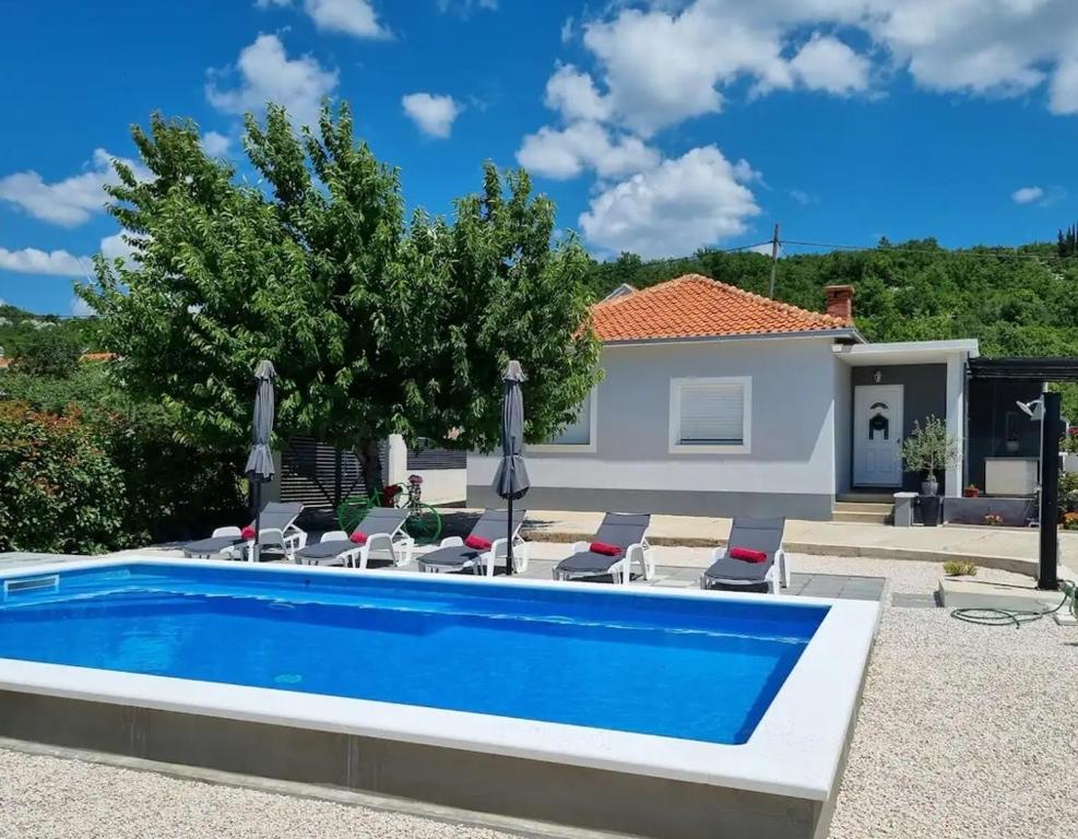 a swimming pool in front of a villa at Family friendly house with a swimming pool Sestanovac, Zagora - 22984 in Šestanovac