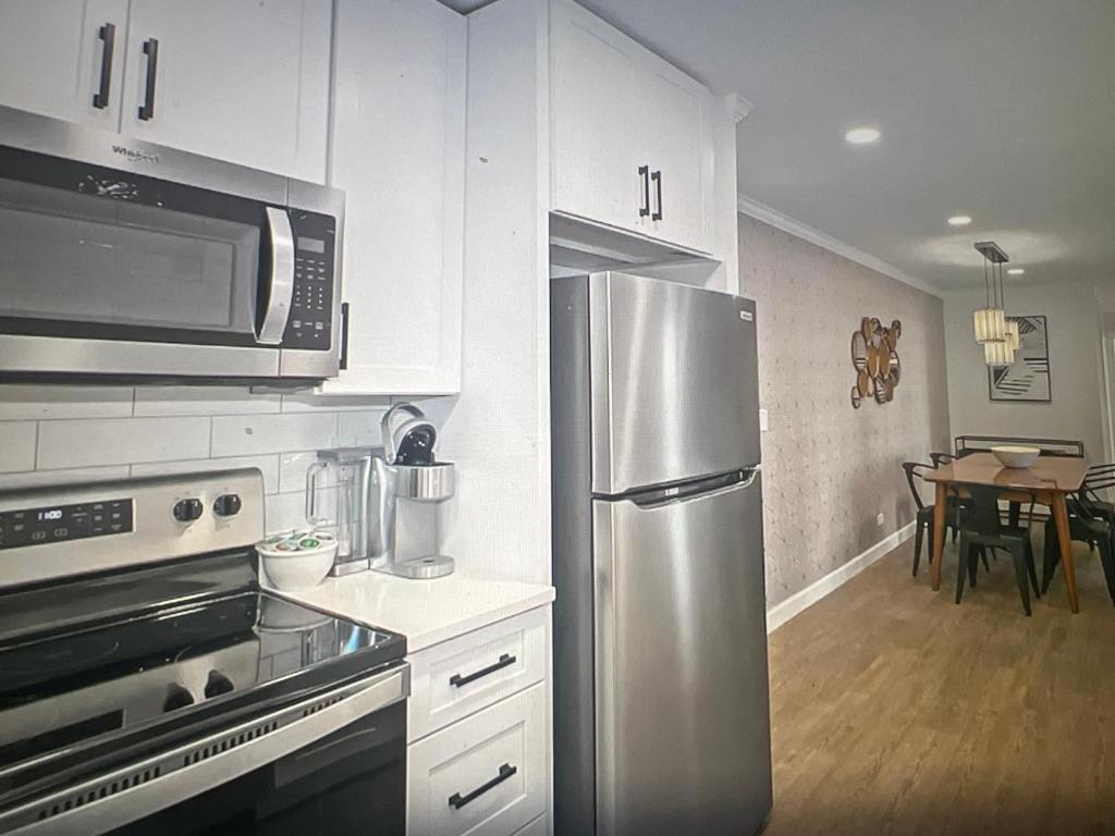 eine Küche mit einem Kühlschrank aus Edelstahl und einem Tisch in der Unterkunft Simple Comfort; city centre Mayfair in London