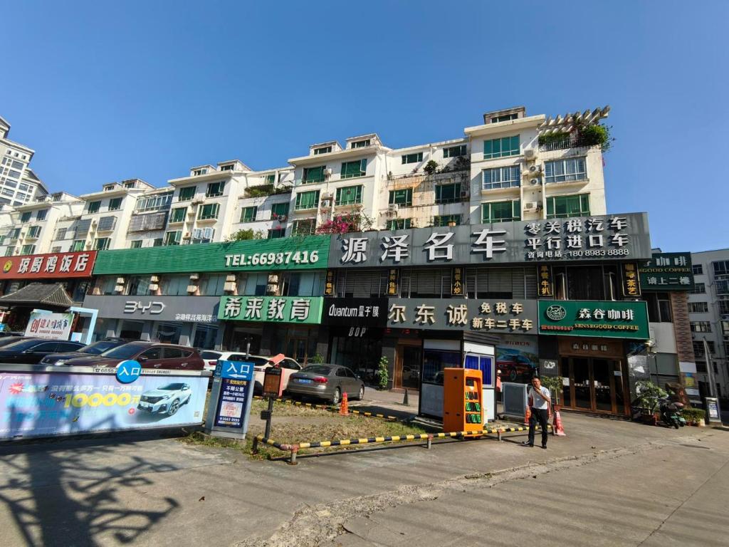 a building with signs on it in a city at Cozy home of Orchid in Haikou