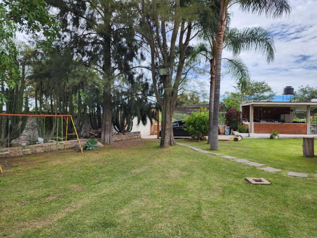 a yard with a swing set and trees at Casa, terraza con alberca, la Cañada in Ixtlahuacán de los Membrillos