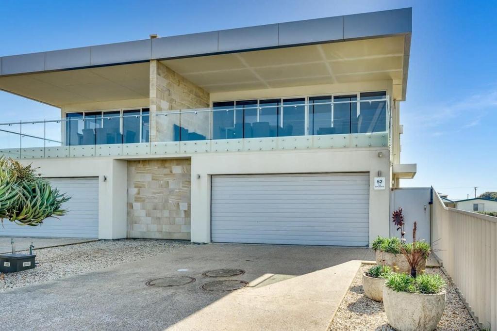 uma casa com duas portas de garagem numa garagem em 52 Esplanade - BYO Linen - Luxury - Seafront - Wi-Fi em Middleton