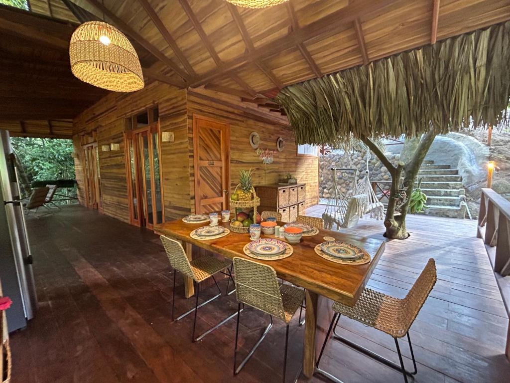 a dining room with a wooden table and chairs at El Retiro De Carolina in Santa Marta