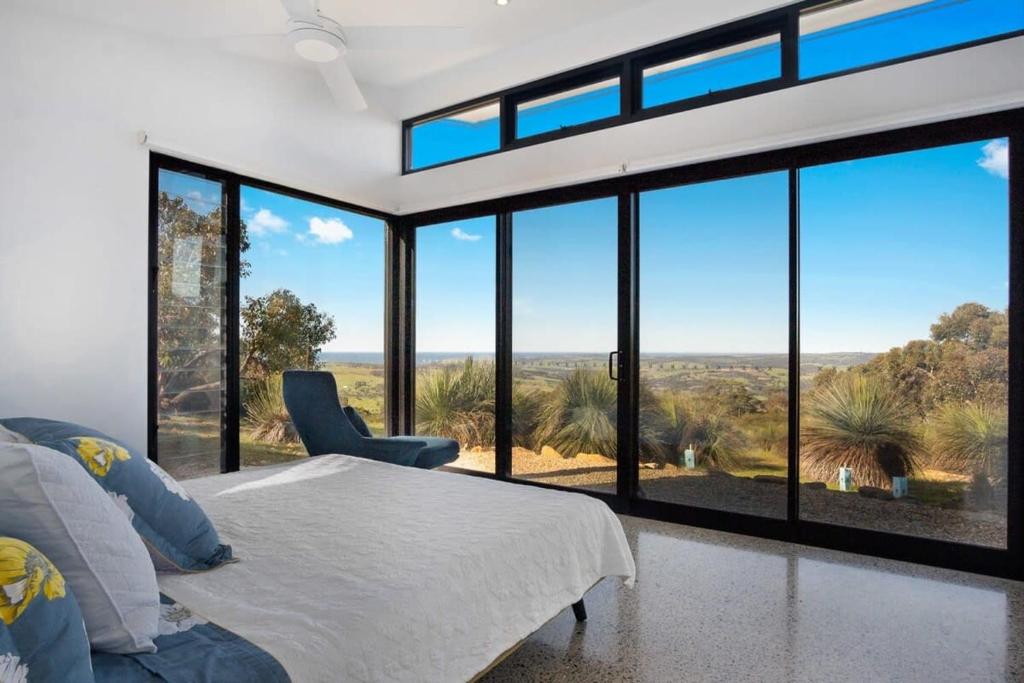 a bedroom with a bed and large glass windows at Acacia - Hindmarsh Valley - Linen Included in Hindmarsh Valley