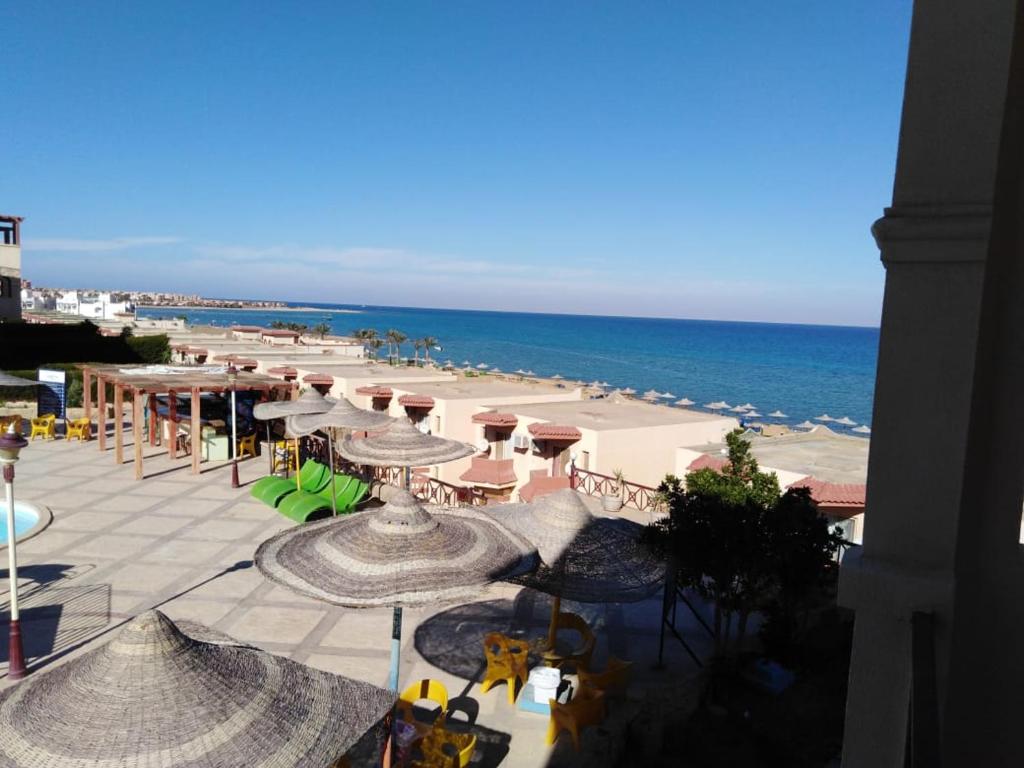 a view of a beach with umbrellas and the ocean at Lasirena Resort Aqua Park-Family Only in Ain Sokhna