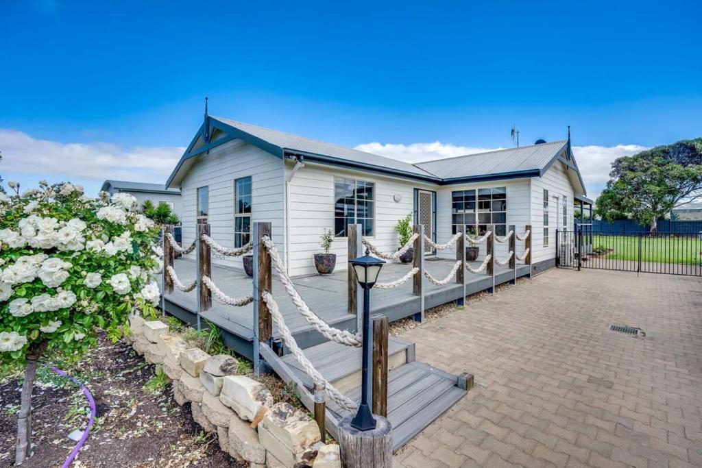 a white house with a porch and a fence at Shanti - 4 Channon St Port Elliot BYO Linen in Port Elliot