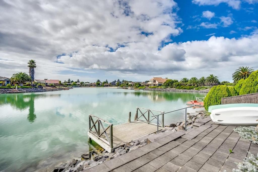 a dock on a lake with a boat on it at Lakehouse28 Waterfront Resort Living Encounter Bay - BYO Linen in Encounter Bay