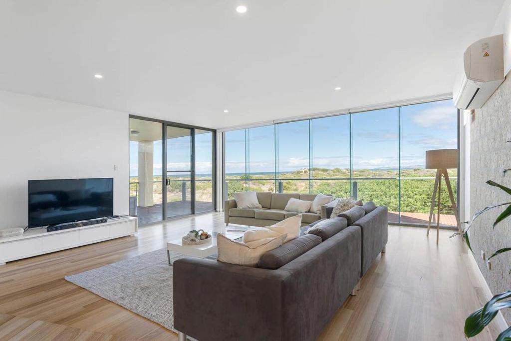 ein Wohnzimmer mit einem großen Sofa und einem TV in der Unterkunft Samphire Middleton-Beach - BYO Linen - Wi-Fi-Luxury-Family in Middleton
