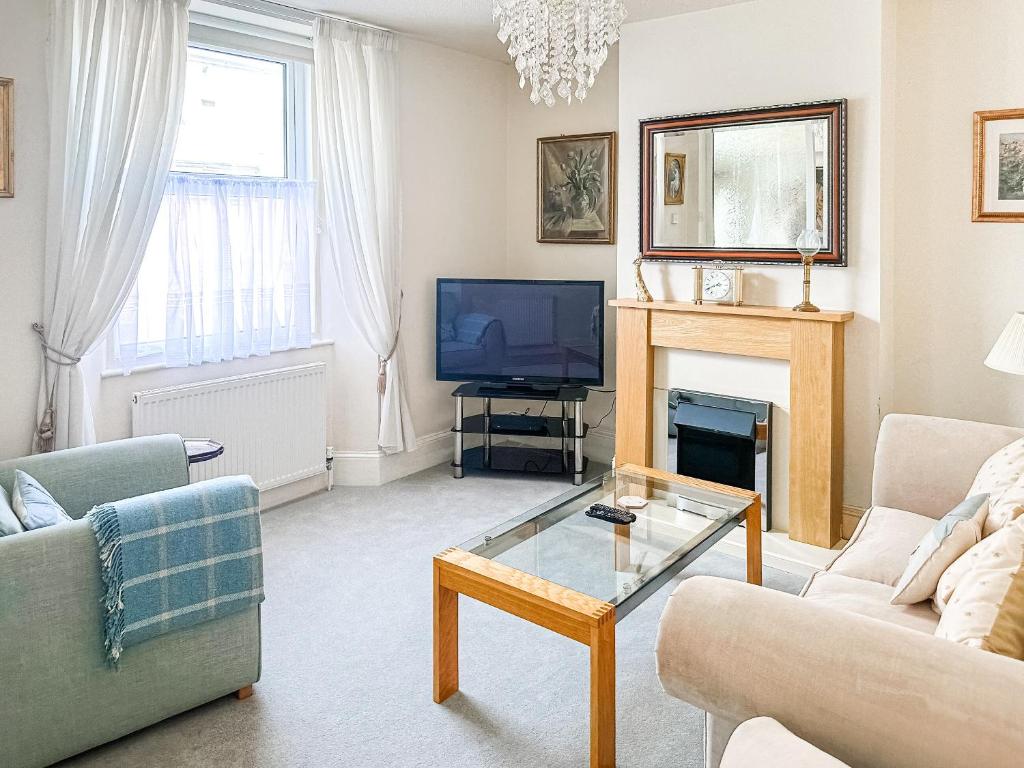 a living room with a fireplace and a tv at St Annes Road in Torquay