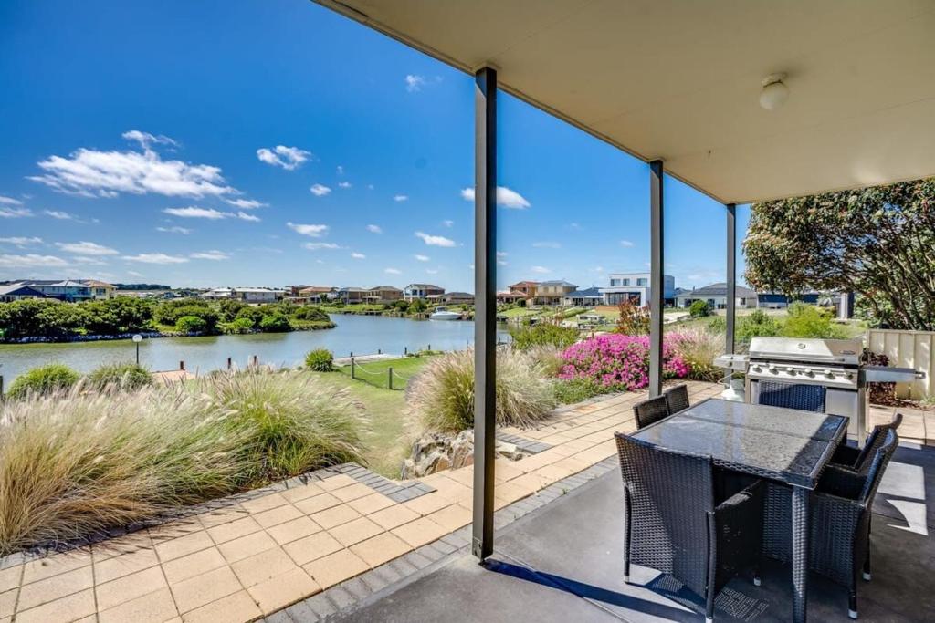 a patio with a table and chairs and a view of a river at T2 12 Wentworth Pde Hindmarsh Island - No Linen Included in Hindmarsh Island