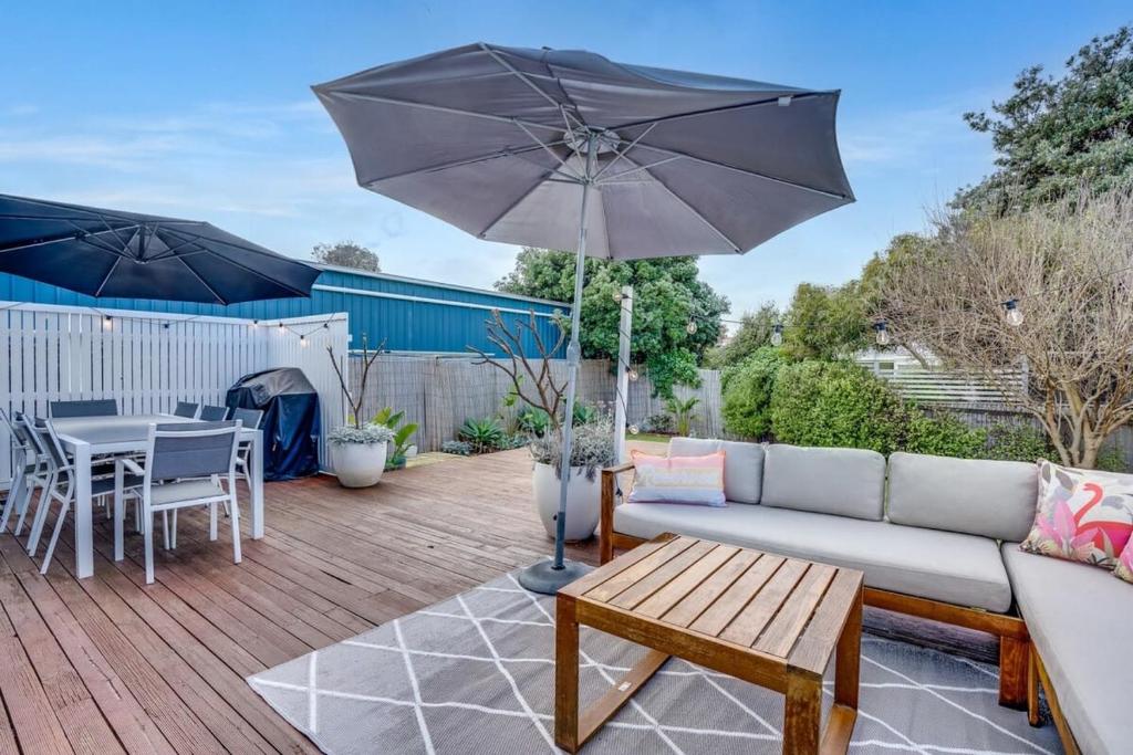 a patio with a couch and a table with an umbrella at 32 Beach Rd Goolwa South-No Linen Included in Goolwa South