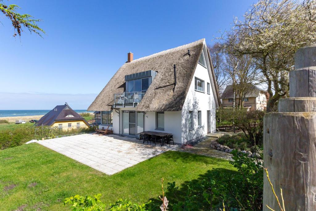 un cottage avec un toit de chaume sur une pelouse dans l'établissement Haus ANNA, à Ahrenshoop