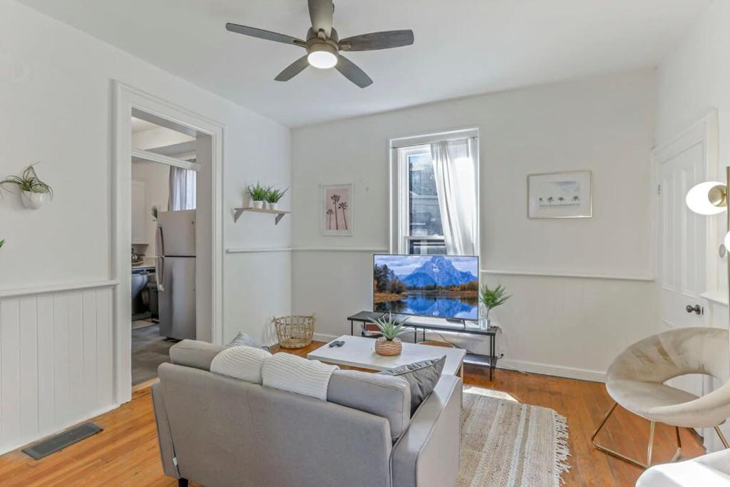 a living room with a couch and a ceiling fan at Housepitality - The Short North Sanctuary in Columbus