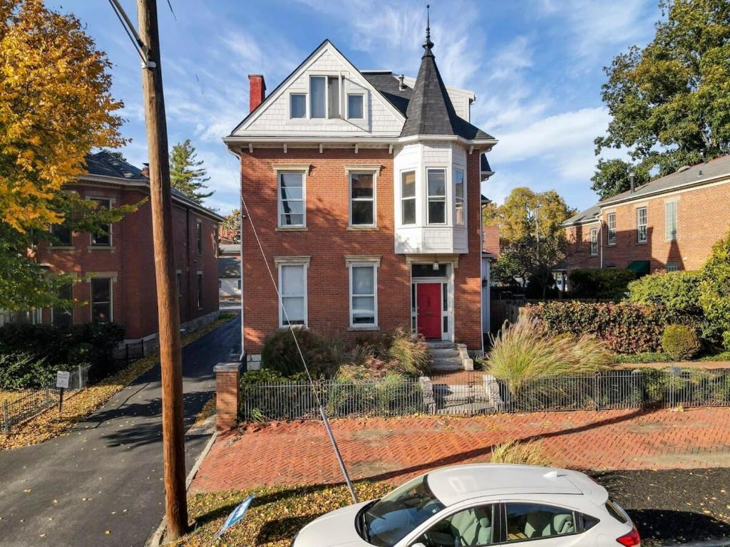 a white car parked in front of a house at Housepitality - The Capital House - 5 BR Downtown in Columbus