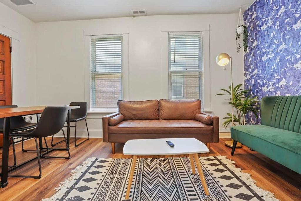 ein Wohnzimmer mit einem Sofa und einem Tisch in der Unterkunft Housepitality - Cityscape - Historic 2BR in Columbus