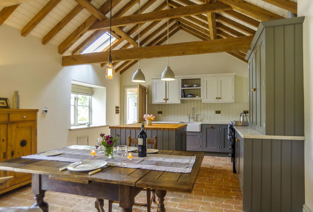 a kitchen with a wooden table in a room at Pea Cottage in Stamford