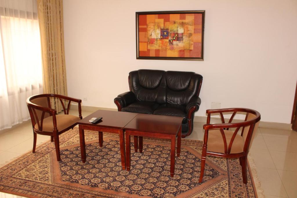 a living room with a couch and a table and a chair at Hotel Residence Flamani in Lomé