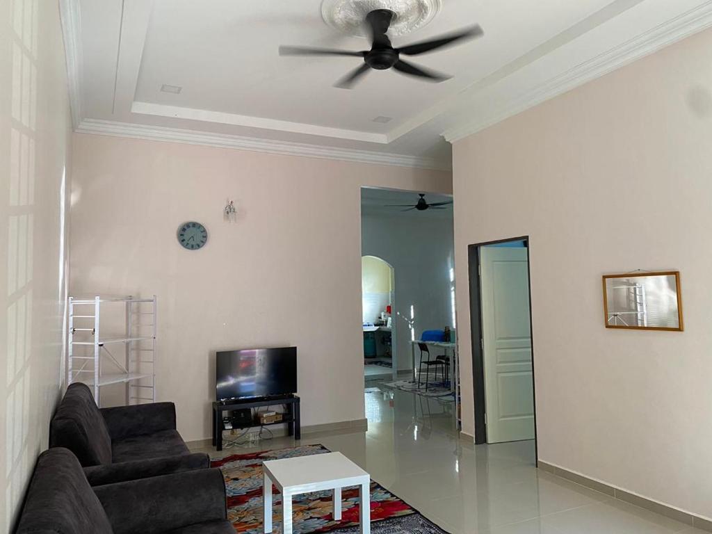Il comprend un salon doté d'un ventilateur de plafond et d'une télévision. dans l'établissement Zayyans Homestay, à Kampong Merabang Likar