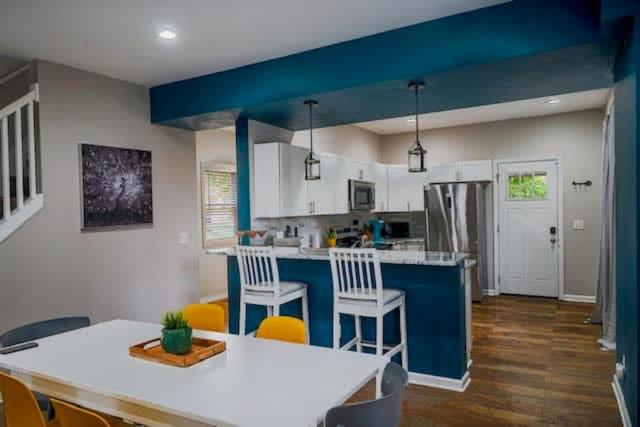 a kitchen with blue walls and a table and chairs at Housepitality - The Lilley Pad - Near Downtown in Columbus