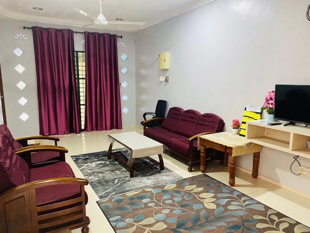 a living room with a purple couch and a tv at ZR Homestay Kemaman with 3 Bedroom 2 Bathroom - 2 Room AC 1 Room Fan - Not Sharing House in Cukai