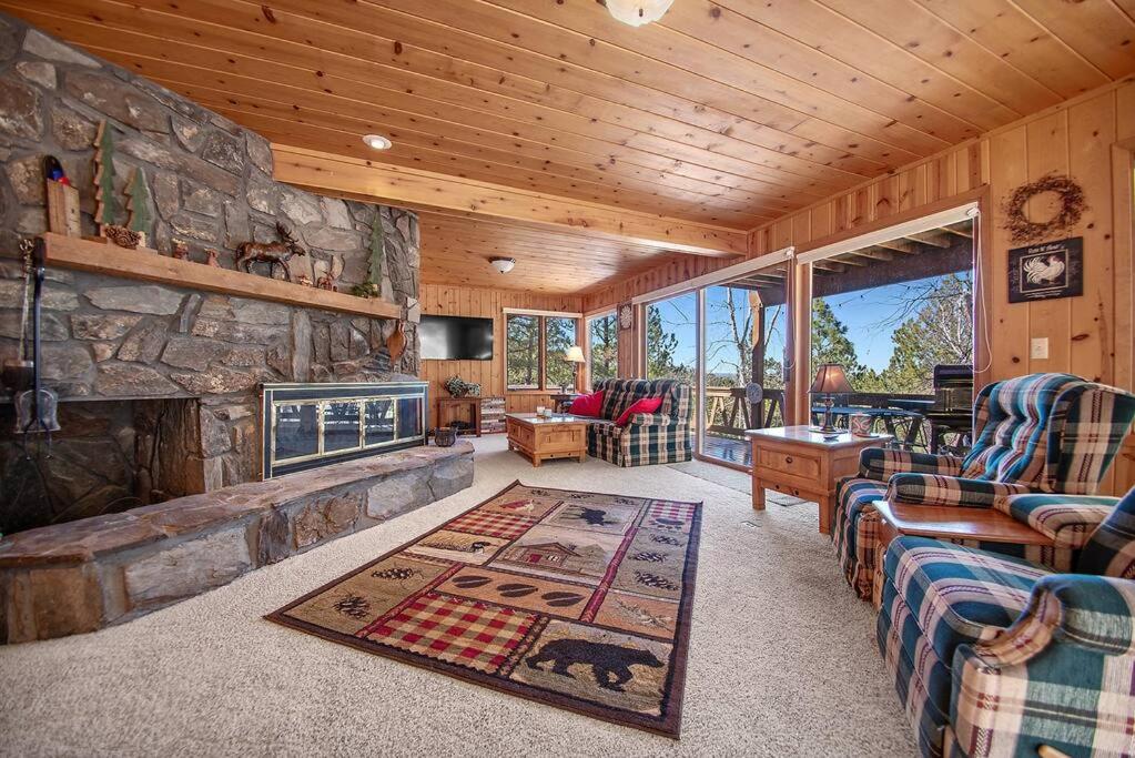 a living room with a stone fireplace in a cabin at Holiday House in Rapid City