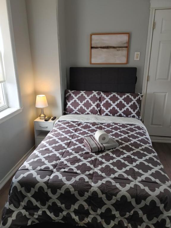 Schlafzimmer mit einem Bett mit einer schwarzen und weißen Bettdecke in der Unterkunft 32 jean economic room 1.6 in Saint John