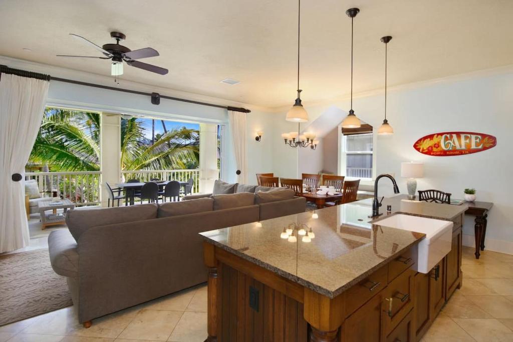a kitchen and living room with a couch and a table at D211 Second Floor 3-bedroom Poolside Lanai in Koloa