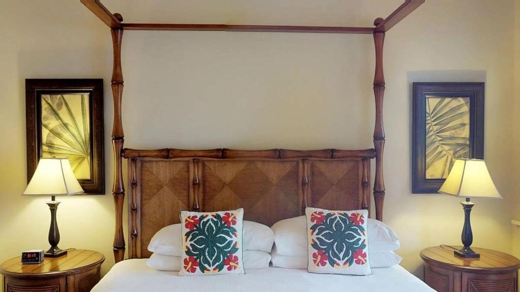 a bedroom with a canopy bed with two lamps at F211 Second Floor 3-bedroom Poolside Lanai in Koloa