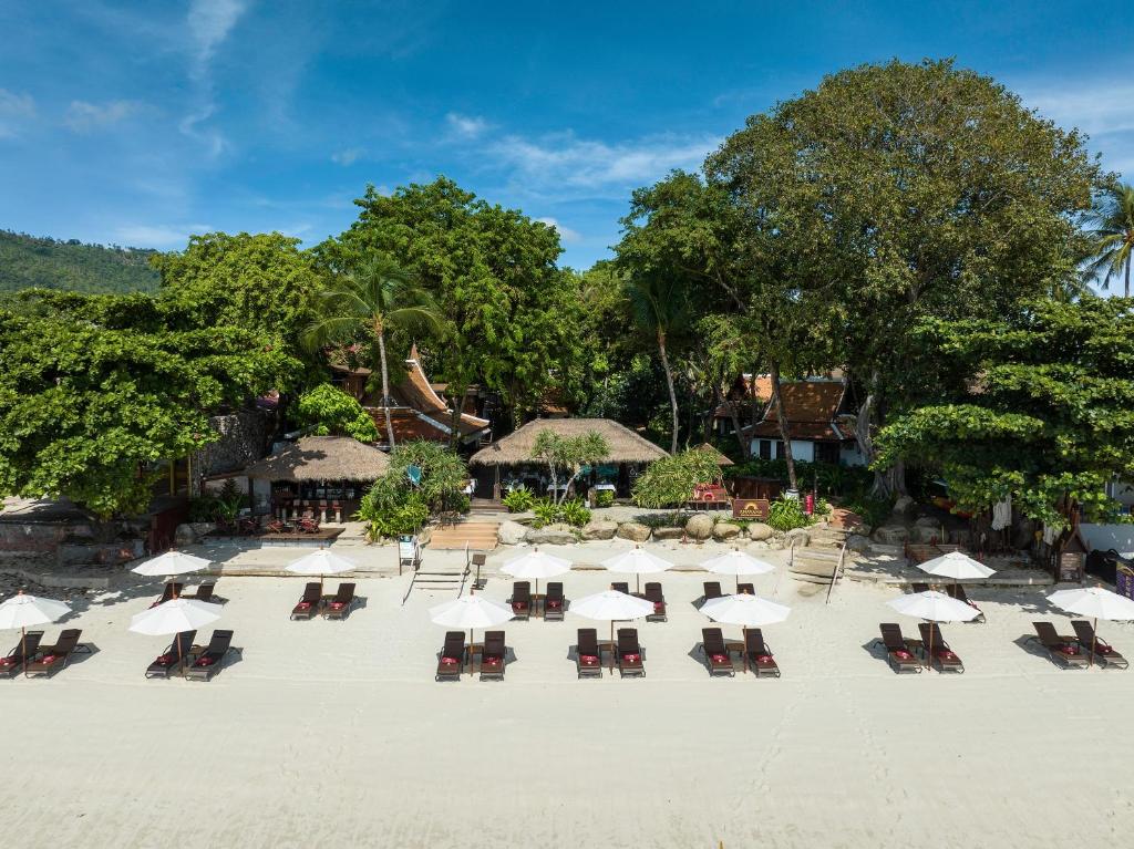 a group of tables and chairs with umbrellas on a beach at Anavana Beach Resort in Chaweng