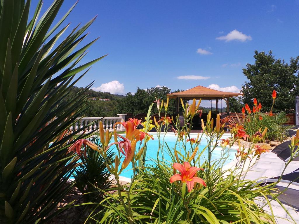 a swimming pool with flowers and a gazebo at Appartement Vue Montagne in Garéoult