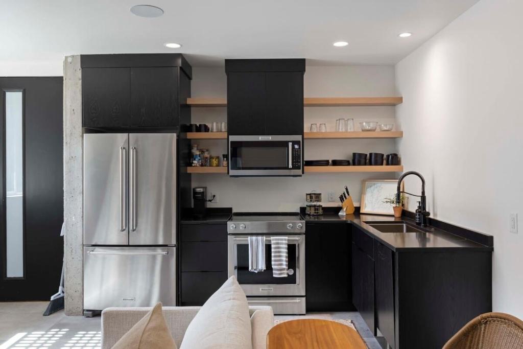 a kitchen with black cabinets and stainless steel appliances at Zion loft basement unit 5 in Springdale