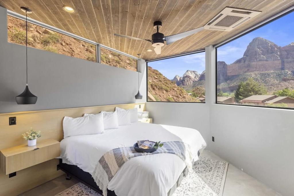 a bedroom with a bed and large windows at The Loft at Zion in Springdale