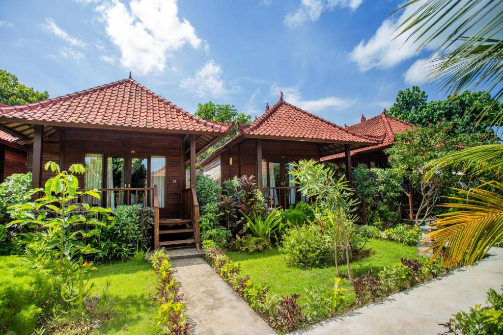 una casa con un jardín delante de ella en The Parnas, en Nusa Lembongan