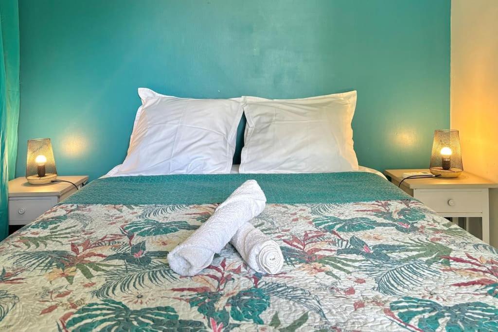 een bed met twee handdoeken en twee lampen bij Le refuge de Chrystel : Plage accessible à pied in Le Gosier