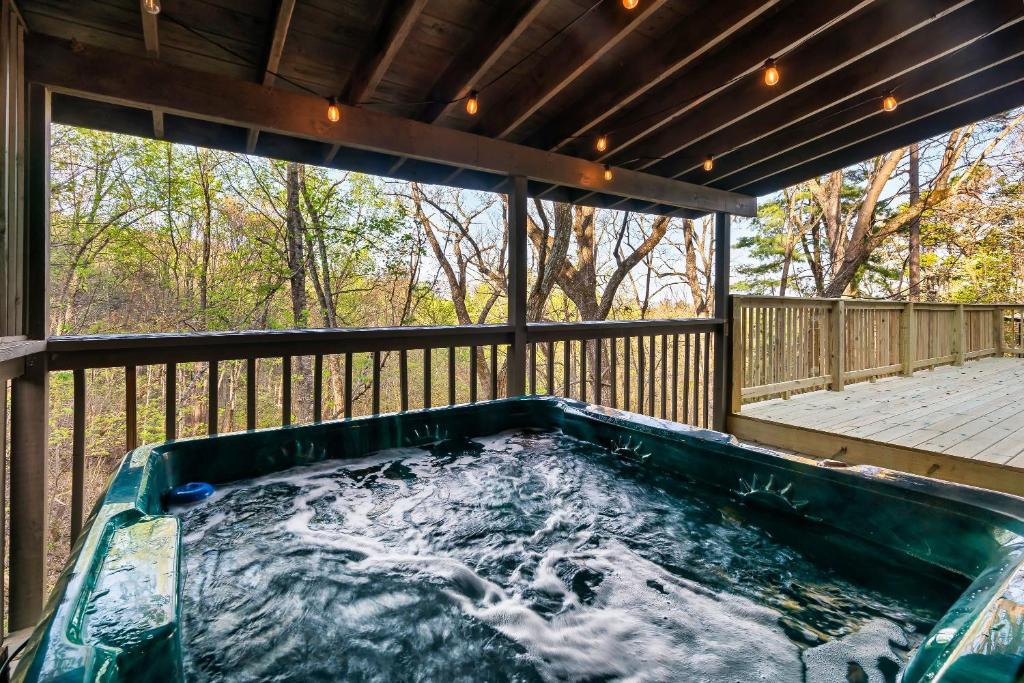 a hot tub on the deck of a house at NEW Cabin with Spectacular View with HOT TUB in the Smoky MTNS in Sevierville