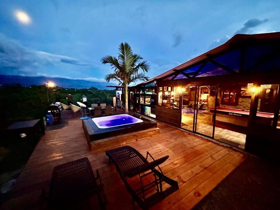 une maison avec une terrasse et une piscine dans l'établissement Cabaña entre montañas + Jacuzzi, à Quindío