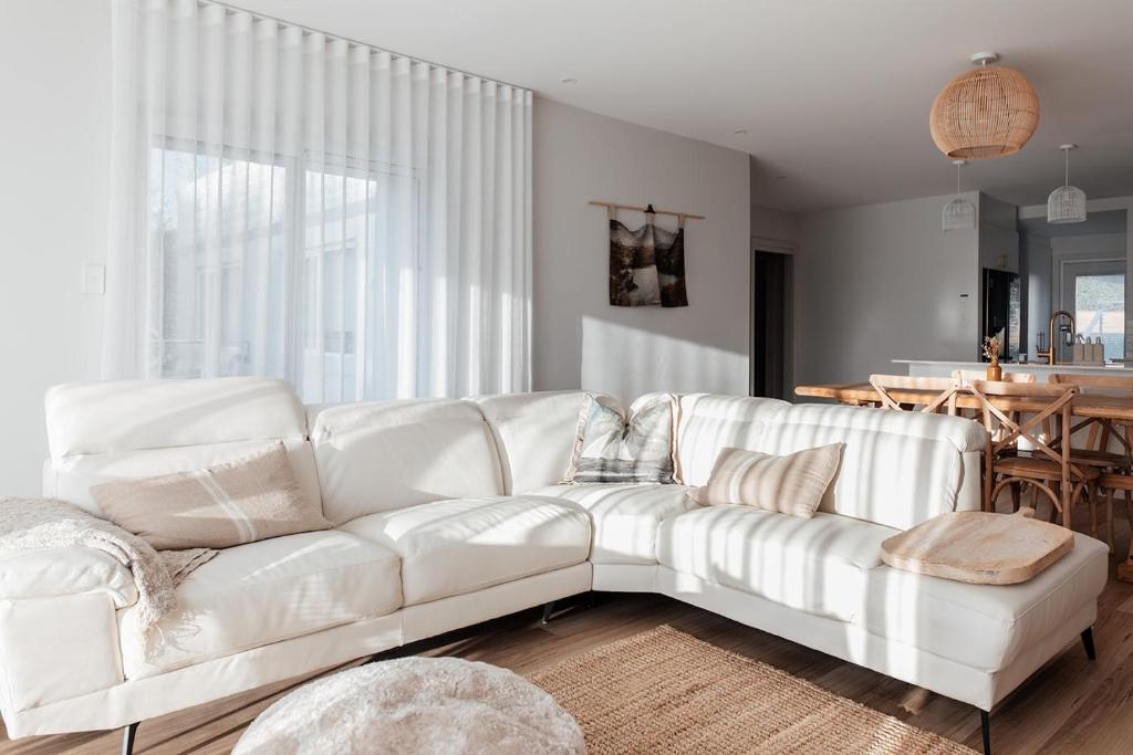 un sofá blanco en una sala de estar con mesa en Antalya Beach House, en Bridport