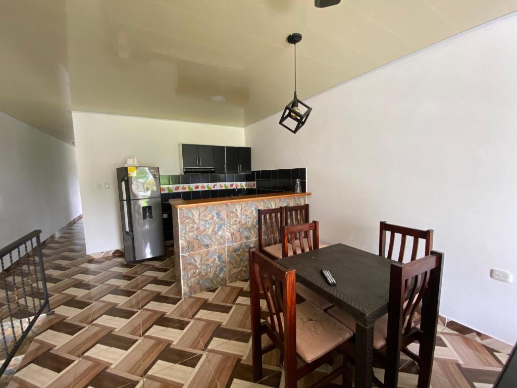 cocina con mesa, sillas y nevera en Apartamento bustos en Puerto Triunfo