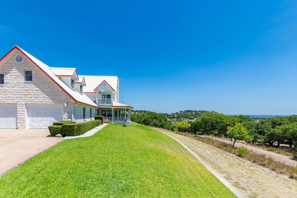 a large house with a large grass yard at Gaushaus Royal Oaks in Fredericksburg