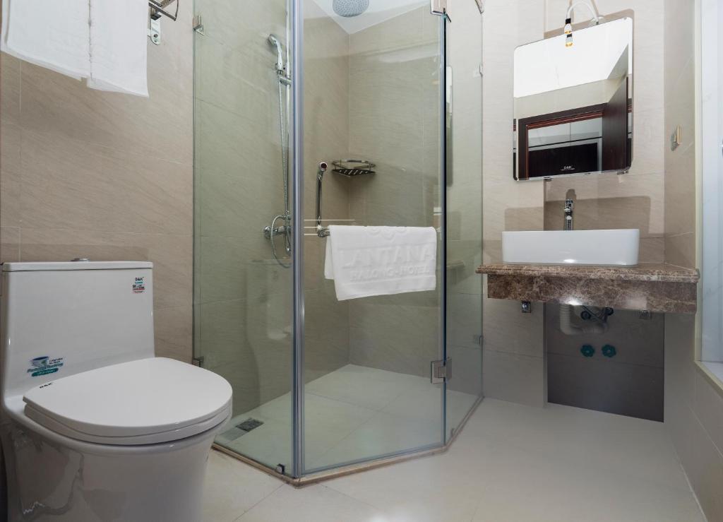 uma casa de banho com um chuveiro, um WC e um lavatório. em LANTANA Hạ Long Hotel E409 SUNPLAZA Phố đi bộ, Bãi Cháy, Hạ Long em Ha Long