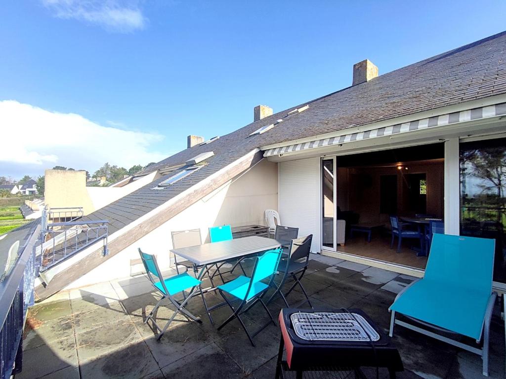 un patio avec une table et des chaises sur un balcon dans l'établissement Duplex avec Terrasse, à 250 m de la Plage du Fogeo et Proche Commerces - FR-1-639-114, à Arzon
