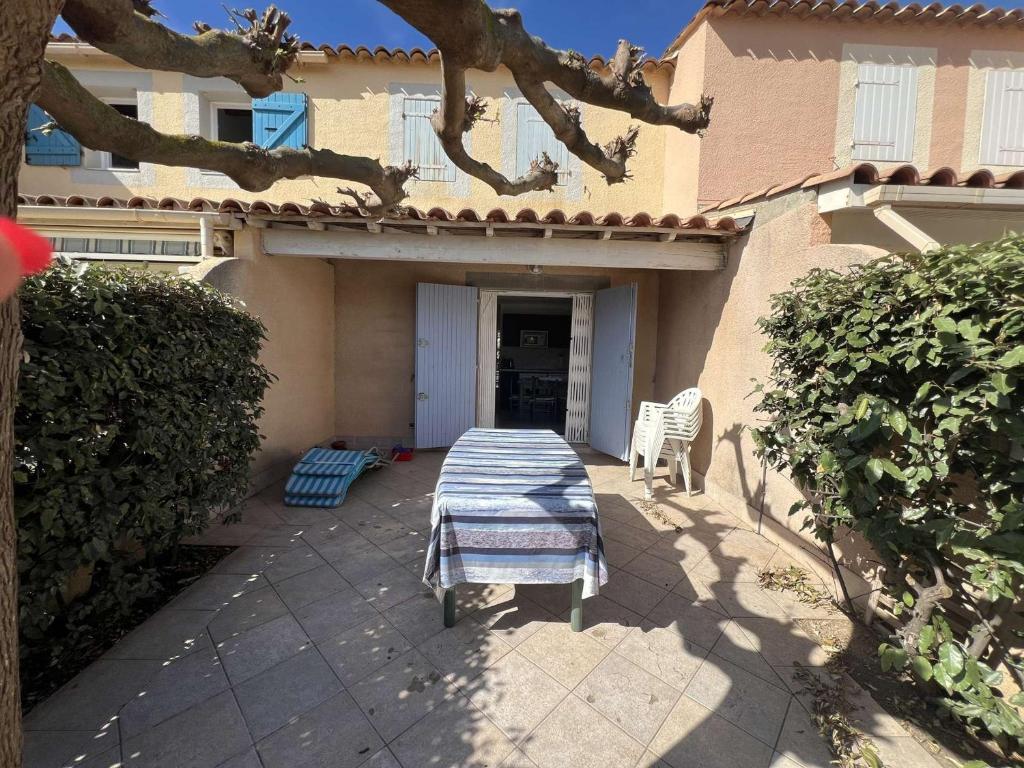 une table et des chaises assises à l'extérieur d'une maison dans l'établissement Pavillon cosy, proche plage et commerces, pour 6 pers., avec terrasse, garage et équipements modernes - FR-1-701-80, à Valras-Plage