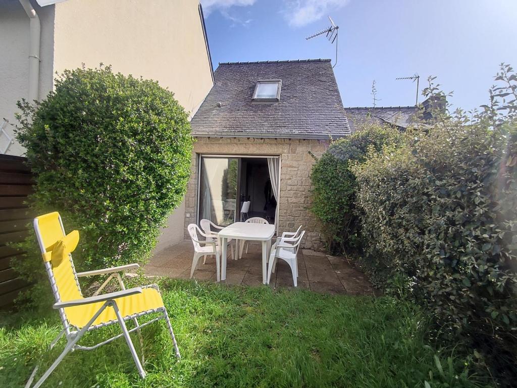 un patio avec une table et des chaises dans une cour dans l'établissement Maison cosy près de la plage de Kerfontaine, idéale pour 3 personnes avec jardin et parking - FR-1-639-113, à Sarzeau